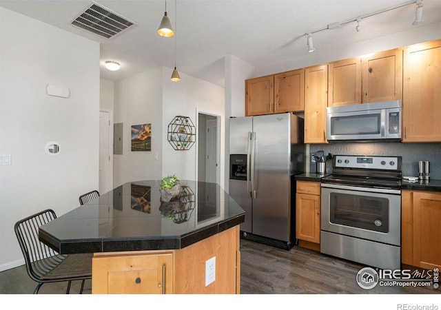 kitchen with a breakfast bar area, decorative light fixtures, a center island, dark hardwood / wood-style floors, and stainless steel appliances