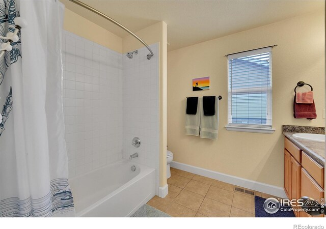 full bathroom with shower / tub combo with curtain, tile patterned floors, toilet, and vanity