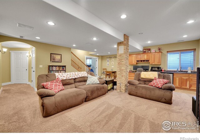 carpeted living room featuring a healthy amount of sunlight and sink