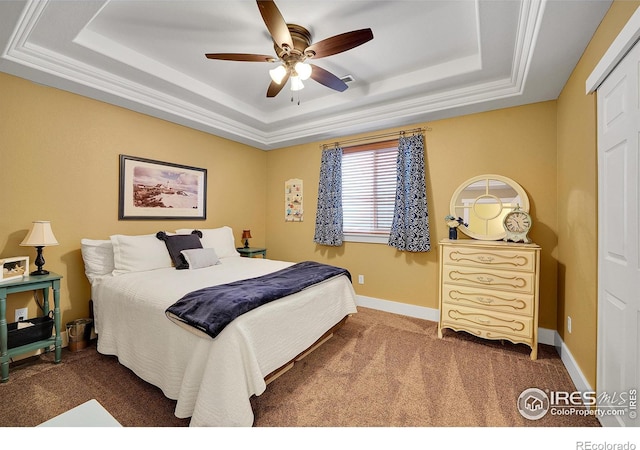 carpeted bedroom featuring ceiling fan and a raised ceiling