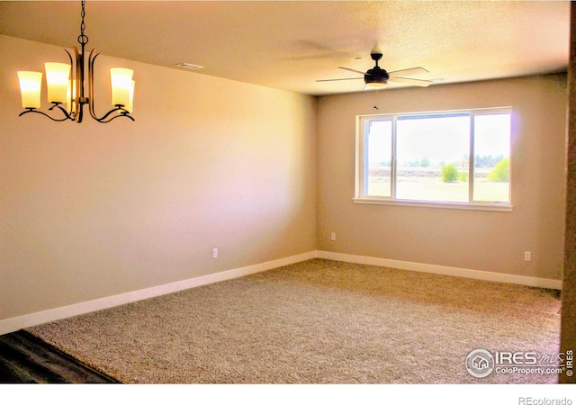 empty room featuring carpet flooring, ceiling fan with notable chandelier, and a textured ceiling