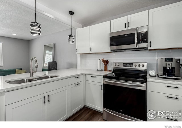 kitchen with pendant lighting, sink, white cabinets, stainless steel appliances, and a textured ceiling