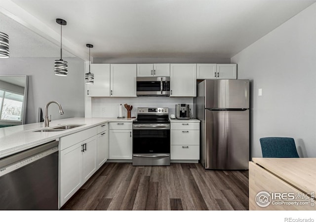 kitchen with decorative light fixtures, sink, white cabinets, dark hardwood / wood-style flooring, and stainless steel appliances