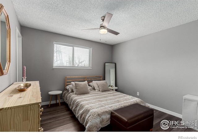 bedroom with ceiling fan, dark hardwood / wood-style floors, and a textured ceiling