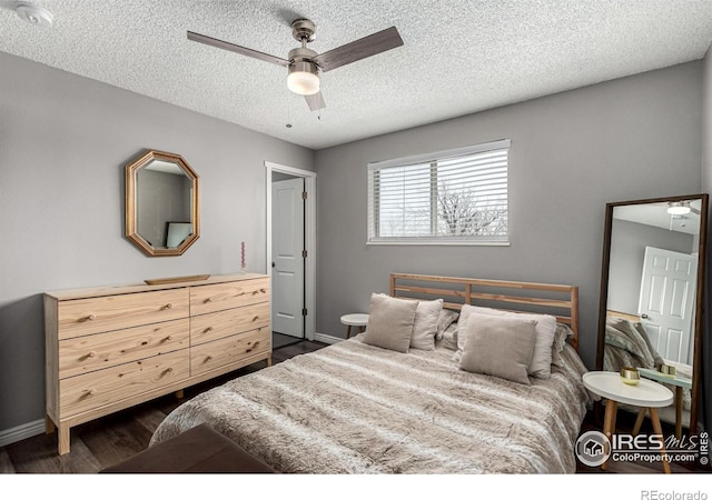 bedroom featuring ceiling fan, dark hardwood / wood-style floors, and a textured ceiling