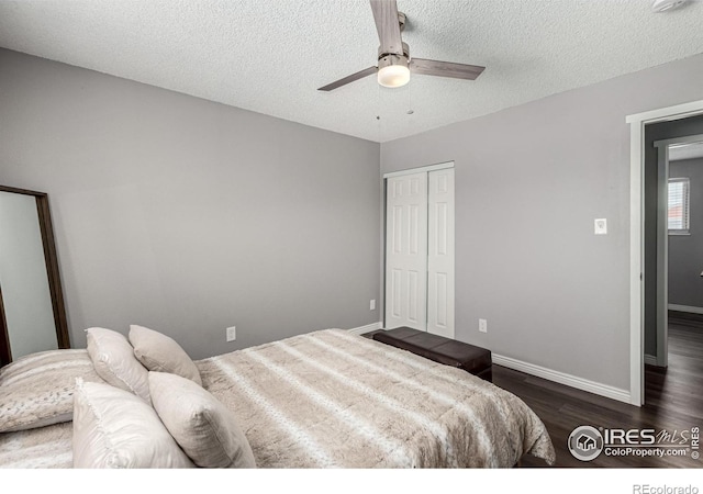 bedroom with dark wood-type flooring, ceiling fan, a closet, and a textured ceiling