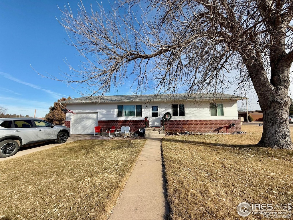 single story home featuring a garage and a front lawn