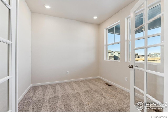 carpeted spare room with french doors