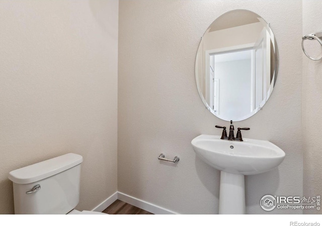 bathroom with wood-type flooring and toilet