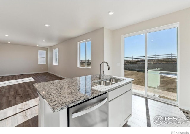 kitchen featuring sink, a center island with sink, dishwasher, light hardwood / wood-style floors, and white cabinets