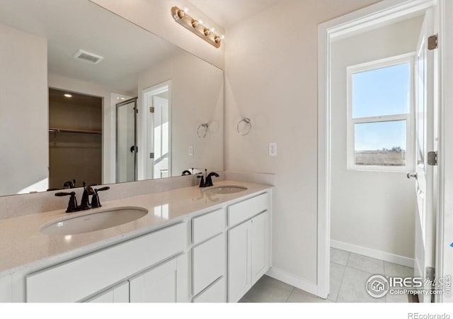 bathroom with tile patterned flooring, vanity, and a shower with shower door