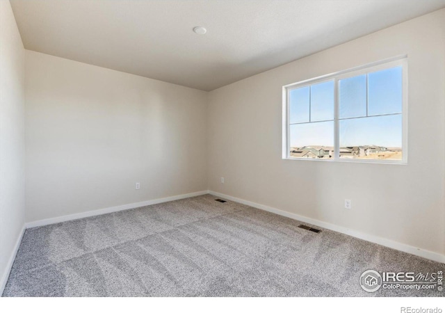 spare room featuring light colored carpet