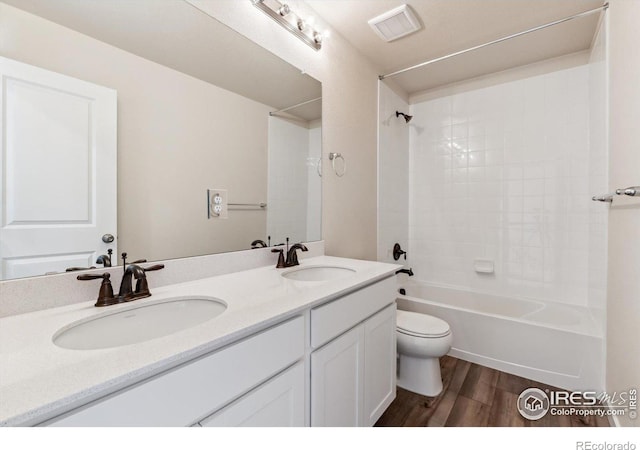 full bathroom featuring shower / bath combination, wood-type flooring, vanity, and toilet