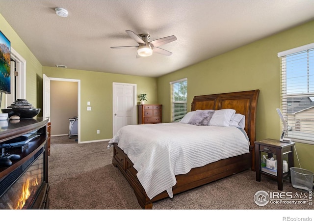 bedroom featuring ceiling fan, a textured ceiling, and carpet flooring