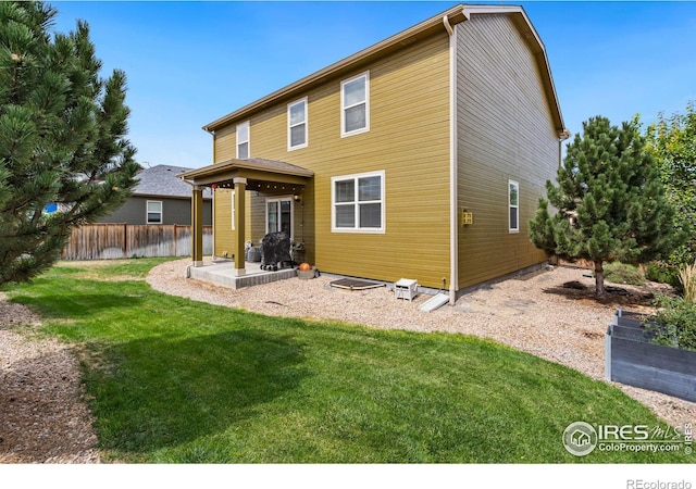 back of property featuring a patio and a lawn