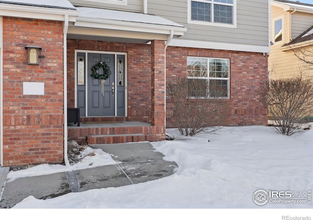 view of snow covered property entrance