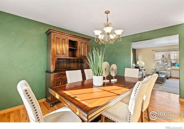 dining space featuring an inviting chandelier and light hardwood / wood-style floors