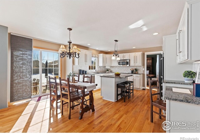 dining area with an inviting chandelier and light wood-type flooring