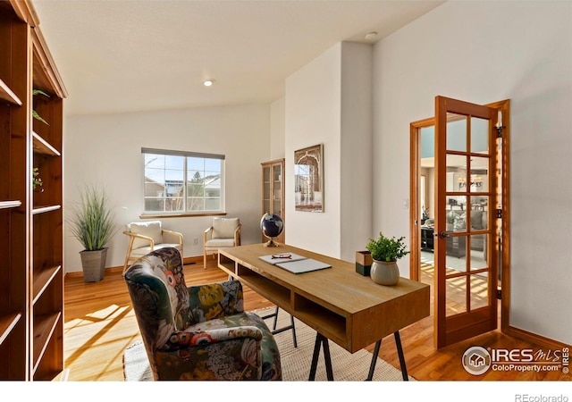 office area with light hardwood / wood-style flooring and vaulted ceiling