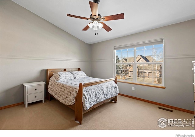 carpeted bedroom with ceiling fan and vaulted ceiling