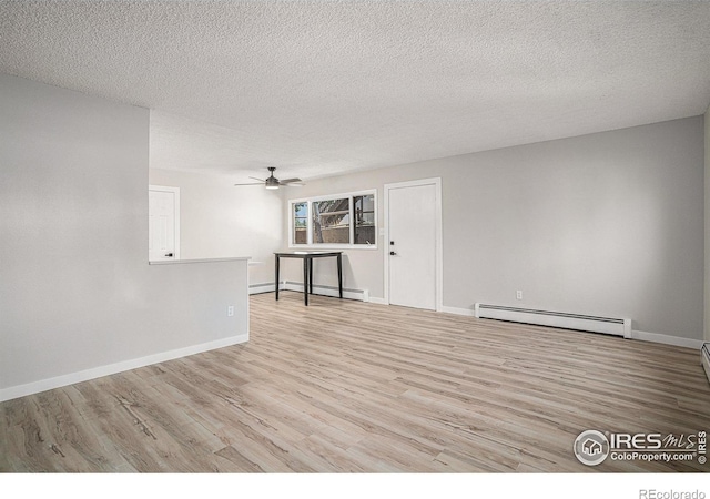 empty room featuring ceiling fan, light hardwood / wood-style floors, a textured ceiling, and a baseboard heating unit