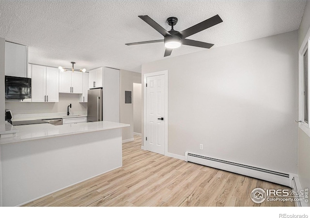 kitchen with sink, appliances with stainless steel finishes, white cabinets, a baseboard radiator, and kitchen peninsula