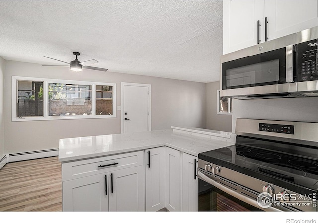 kitchen featuring stainless steel appliances, white cabinetry, a textured ceiling, and light stone counters