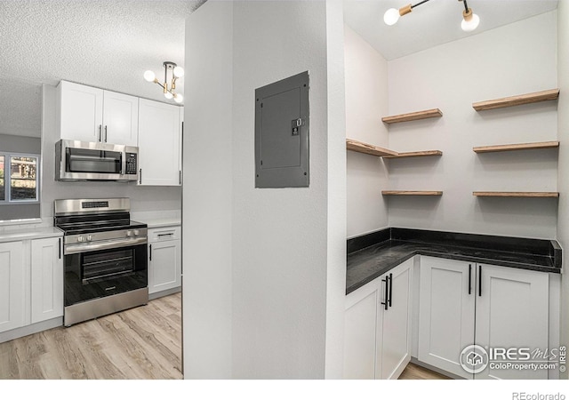 kitchen with white cabinetry, appliances with stainless steel finishes, and electric panel