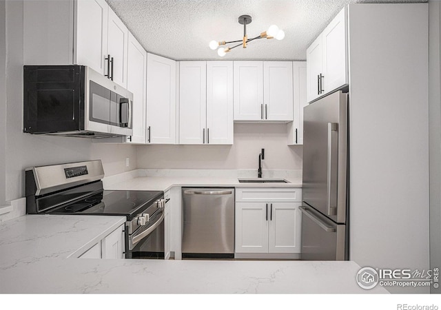 kitchen featuring stainless steel appliances, white cabinetry, and sink