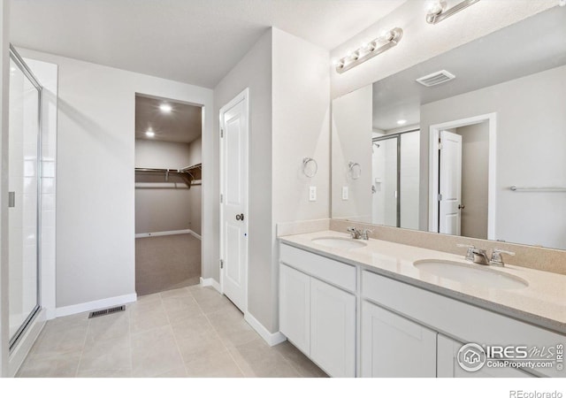 bathroom with vanity, an enclosed shower, and tile patterned floors