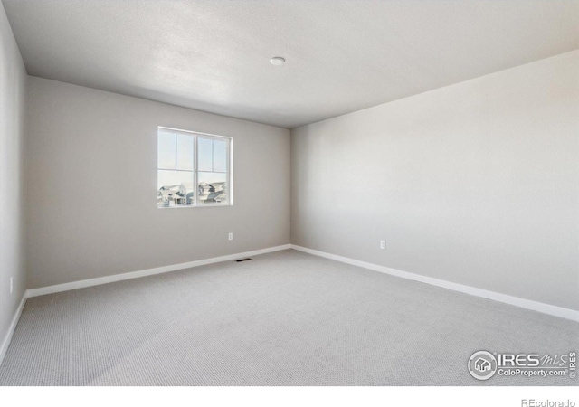 unfurnished room featuring carpet flooring and a textured ceiling