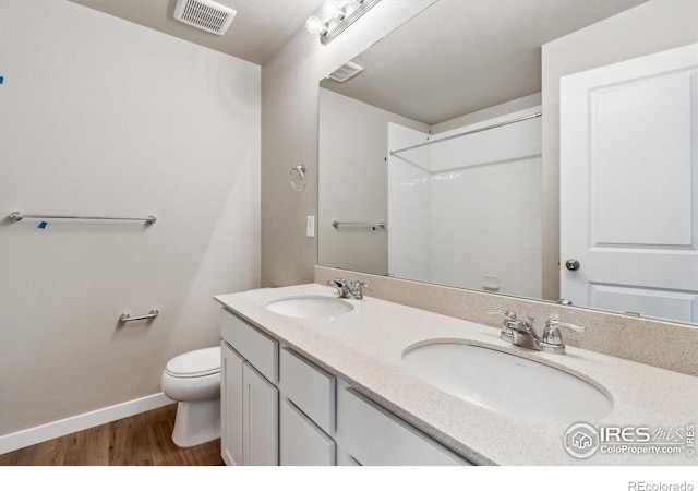 bathroom with vanity, hardwood / wood-style floors, and toilet