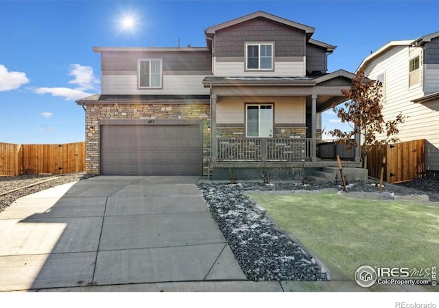 view of front of house featuring a porch, concrete driveway, a garage, and stone siding