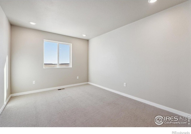 carpeted empty room with baseboards and recessed lighting