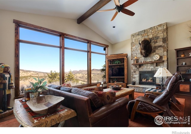 living room with lofted ceiling with beams, ceiling fan, a mountain view, and a fireplace