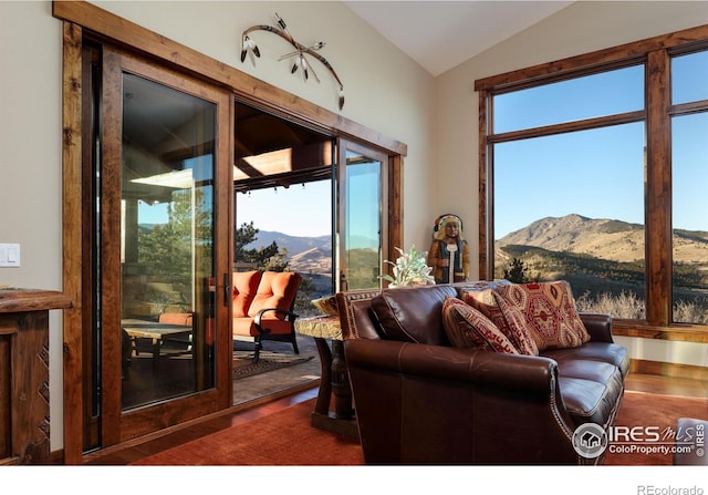 living room featuring a healthy amount of sunlight, a mountain view, and vaulted ceiling