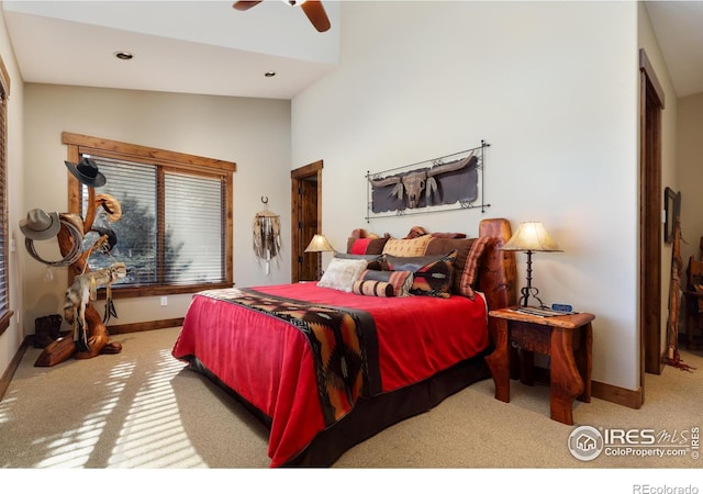 carpeted bedroom with ceiling fan and a towering ceiling