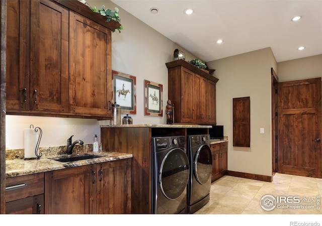 washroom with sink, light tile patterned floors, cabinets, and washer and dryer