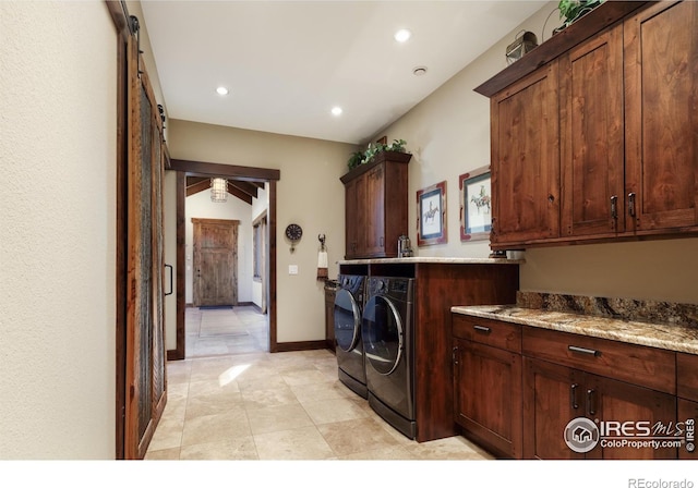 clothes washing area with cabinets and washing machine and clothes dryer