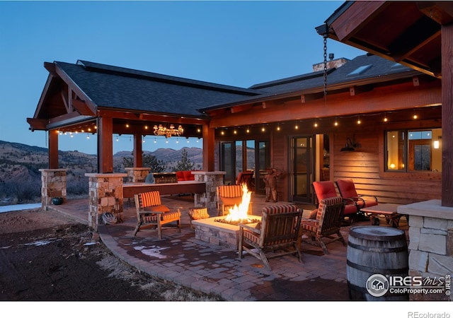 view of patio / terrace with a mountain view and a fire pit