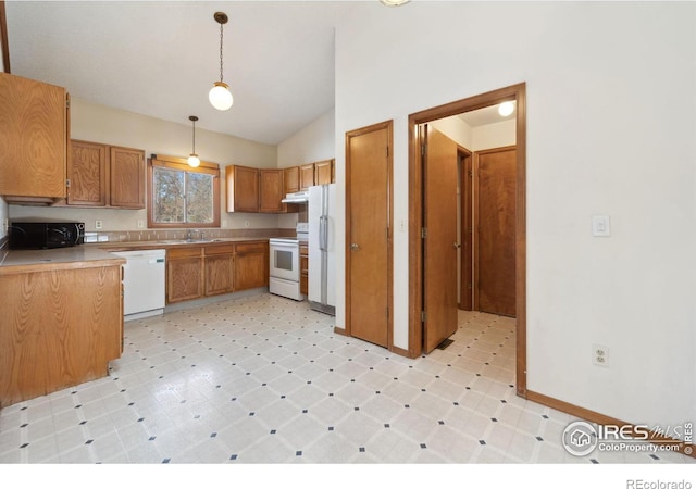 kitchen with pendant lighting, sink, white appliances, and vaulted ceiling