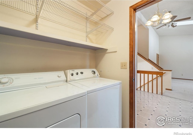 laundry area with washing machine and clothes dryer and a chandelier