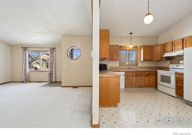 kitchen with sink, decorative light fixtures, light carpet, a textured ceiling, and white appliances