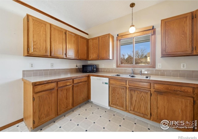 kitchen featuring pendant lighting, dishwasher, sink, and a textured ceiling