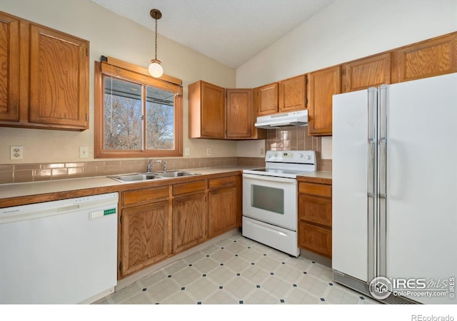 kitchen with vaulted ceiling, decorative light fixtures, tasteful backsplash, sink, and white appliances