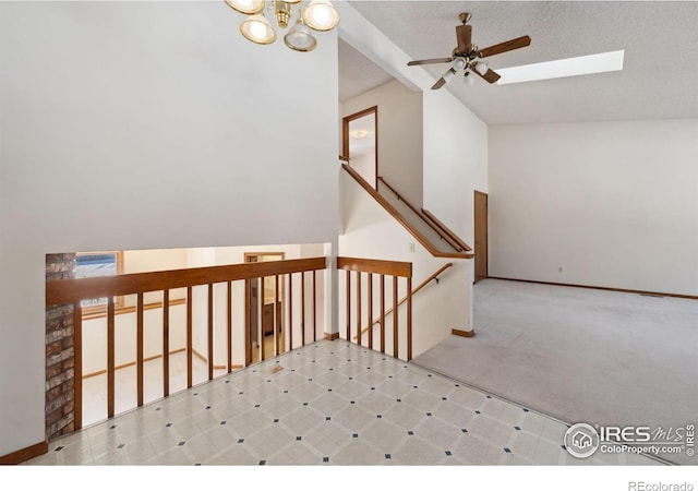 stairway featuring vaulted ceiling with skylight, a chandelier, and carpet floors