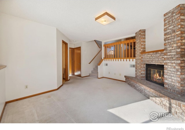 unfurnished living room featuring carpet flooring, a fireplace, and a textured ceiling