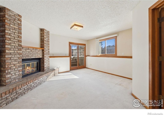 unfurnished living room featuring light colored carpet, a brick fireplace, and a textured ceiling