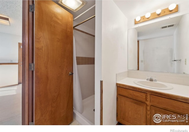 bathroom featuring vanity and curtained shower