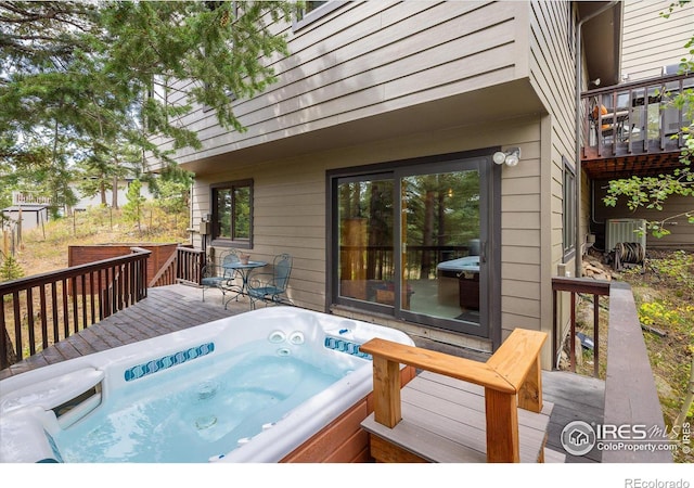 wooden deck with central AC and a hot tub